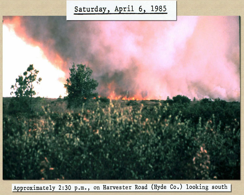 April 6, 1985 2:30 pm: Photo of Initial view of fire burning field from Harvester
				 Road in Hyde County looking south.