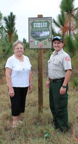 Ranger and FORCES landowner stand on tract of land